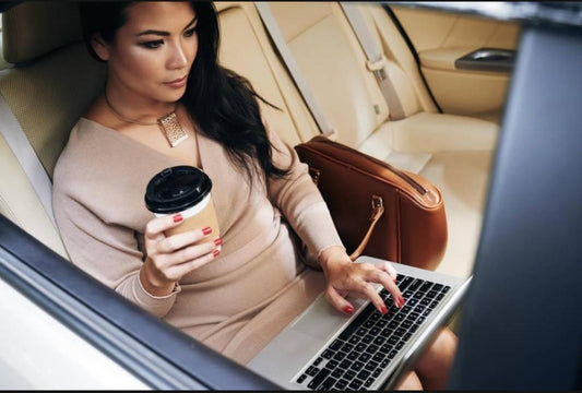 Person relaxing in the backseat of a car, looking content as they travel, symbolizing letting go of control.